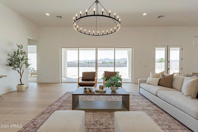 living room featuring a water and mountain view, light hardwood / wood-style floors, and french doors