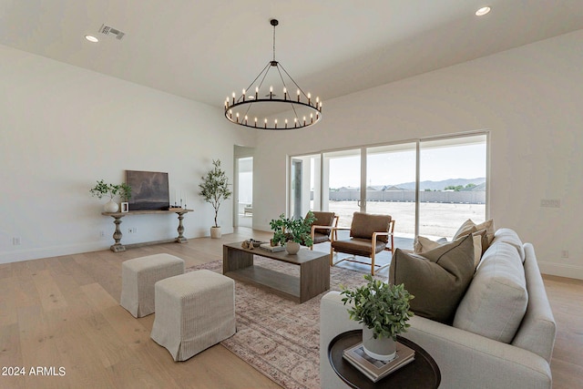 living room with light hardwood / wood-style flooring and an inviting chandelier