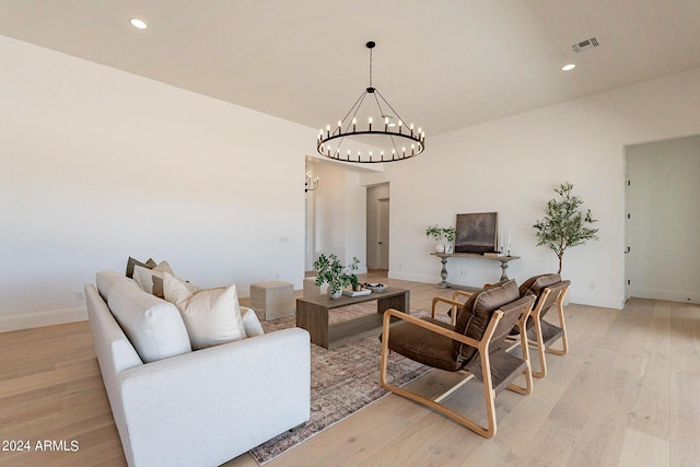 living room featuring light wood-type flooring and an inviting chandelier