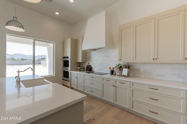 kitchen featuring tasteful backsplash, a mountain view, light hardwood / wood-style flooring, sink, and custom range hood