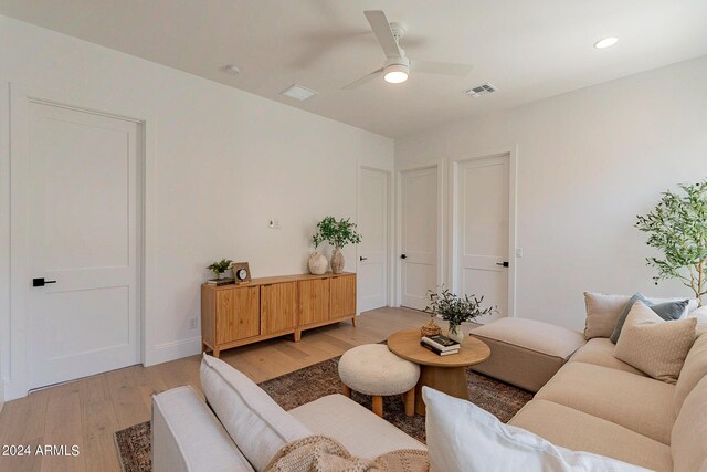 living room featuring ceiling fan and light hardwood / wood-style flooring