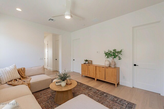 living room featuring light hardwood / wood-style flooring and ceiling fan