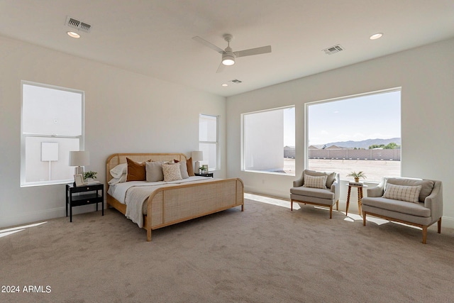 carpeted bedroom featuring a mountain view and ceiling fan