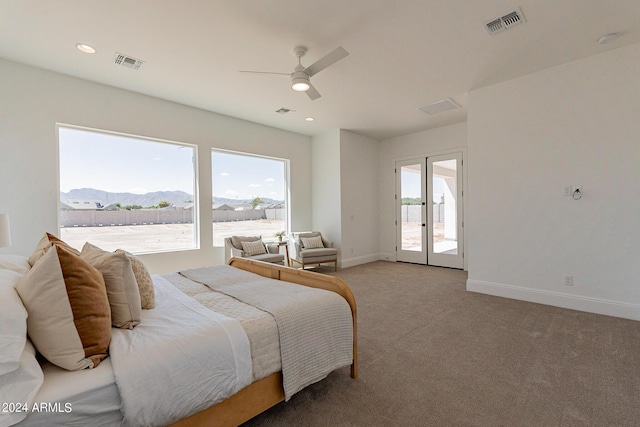 carpeted bedroom with french doors, ceiling fan, a mountain view, and multiple windows