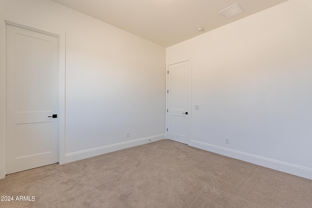 unfurnished room featuring light colored carpet