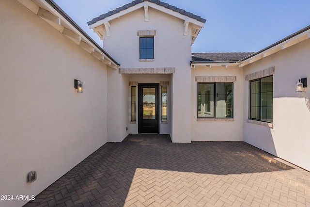 view of exterior entry with a patio area