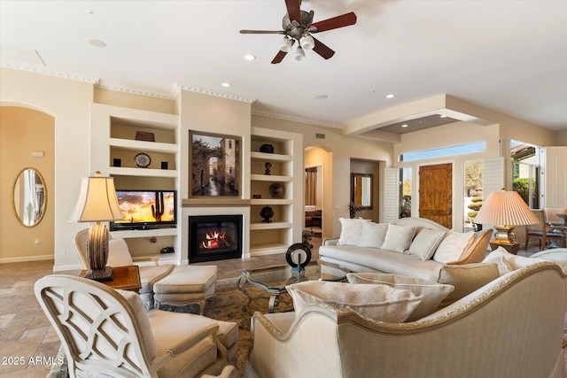 living room featuring built in shelves and ceiling fan