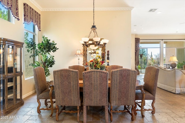 dining area with crown molding and a chandelier