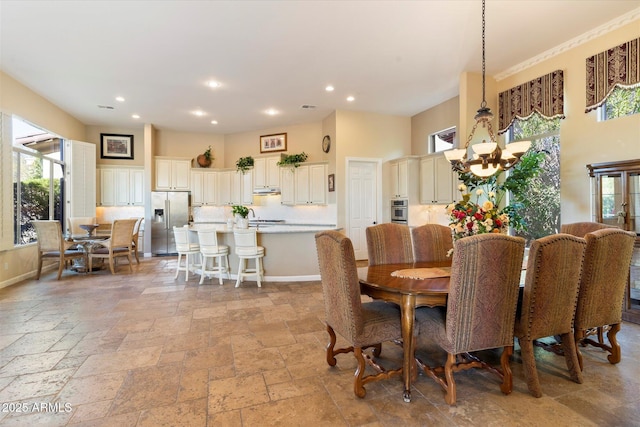 dining area featuring plenty of natural light and an inviting chandelier