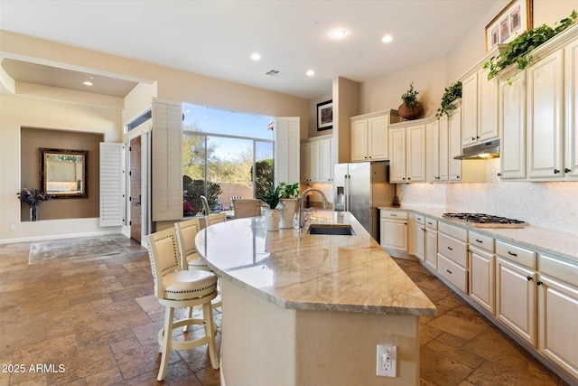 kitchen featuring sink, a center island with sink, and a breakfast bar area