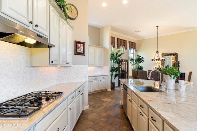 kitchen with pendant lighting, appliances with stainless steel finishes, sink, tasteful backsplash, and light stone countertops