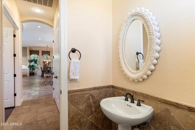 bathroom with sink and tile walls