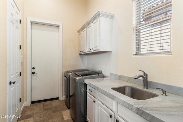 clothes washing area featuring sink, independent washer and dryer, and cabinets