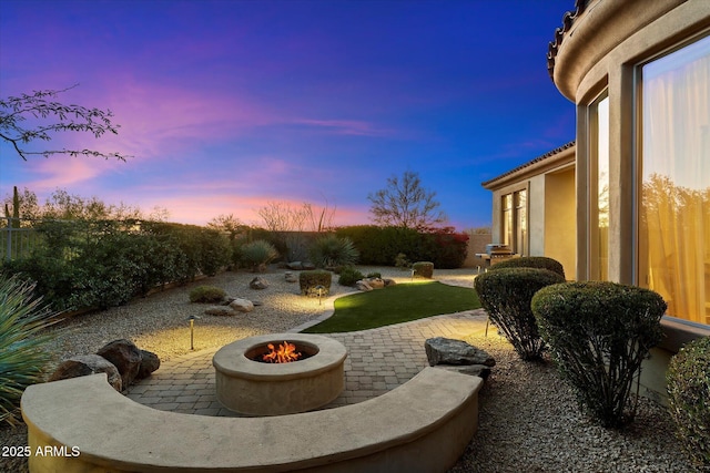 yard at dusk featuring a patio and an outdoor fire pit