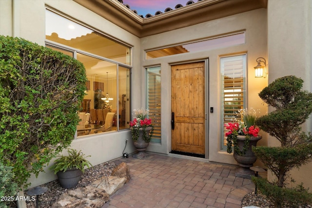 exterior entry at dusk featuring a patio