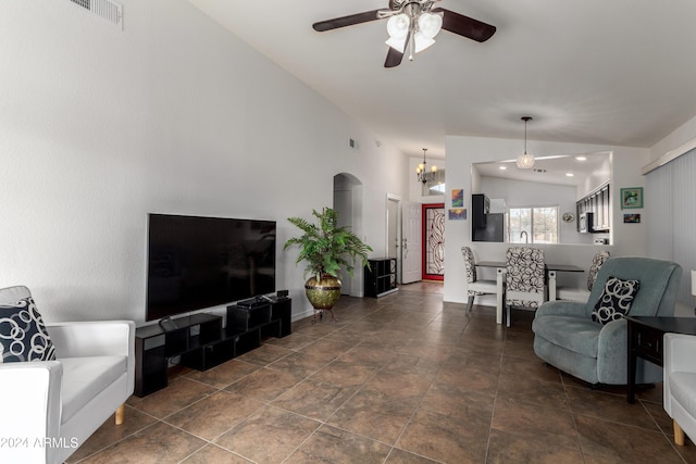 living room with ceiling fan with notable chandelier and lofted ceiling