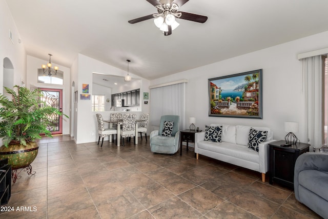 living room with ceiling fan with notable chandelier and vaulted ceiling