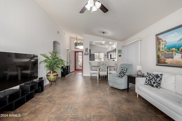 living room featuring ceiling fan with notable chandelier and vaulted ceiling