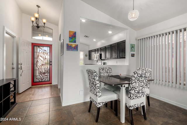 dining area with a chandelier and lofted ceiling