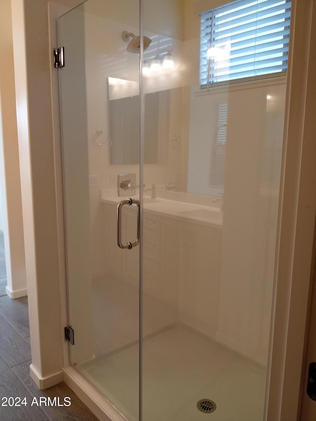 bathroom featuring hardwood / wood-style flooring and walk in shower