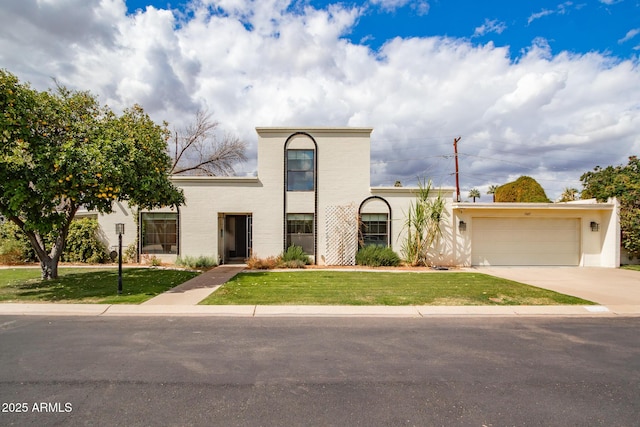 view of front of home featuring a garage, concrete driveway, and a front lawn