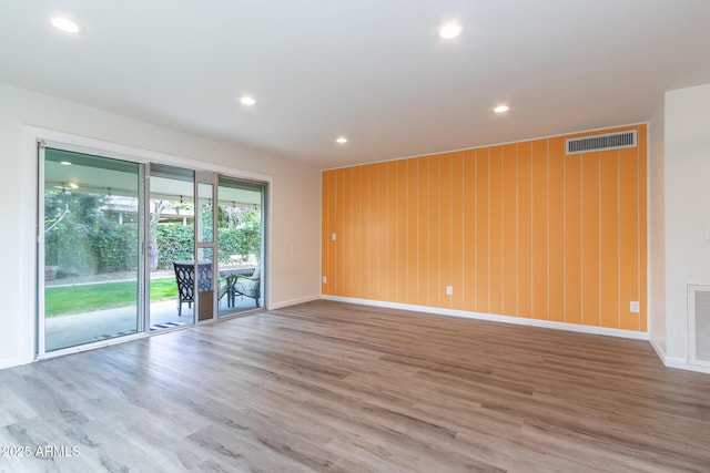 spare room with recessed lighting, visible vents, baseboards, and wood finished floors