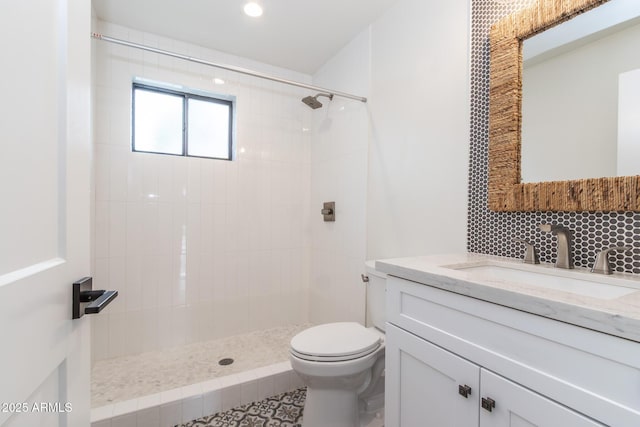 bathroom with vanity, toilet, and a tile shower