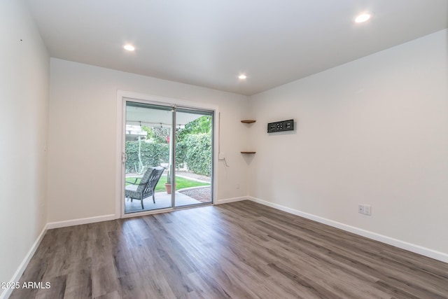 spare room featuring recessed lighting, baseboards, and wood finished floors