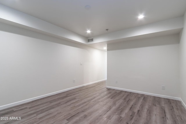 finished below grade area featuring visible vents, recessed lighting, baseboards, and wood finished floors