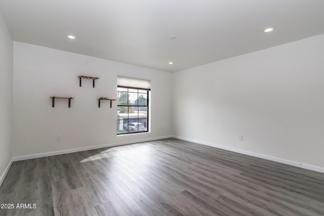 spare room featuring recessed lighting, baseboards, and wood finished floors