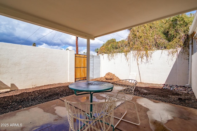 view of patio featuring outdoor dining space and fence