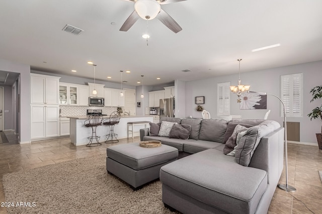 living area with recessed lighting, visible vents, baseboards, and ceiling fan with notable chandelier