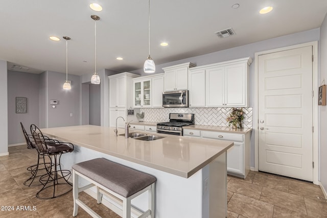 kitchen featuring visible vents, white cabinets, decorative backsplash, stainless steel appliances, and a sink