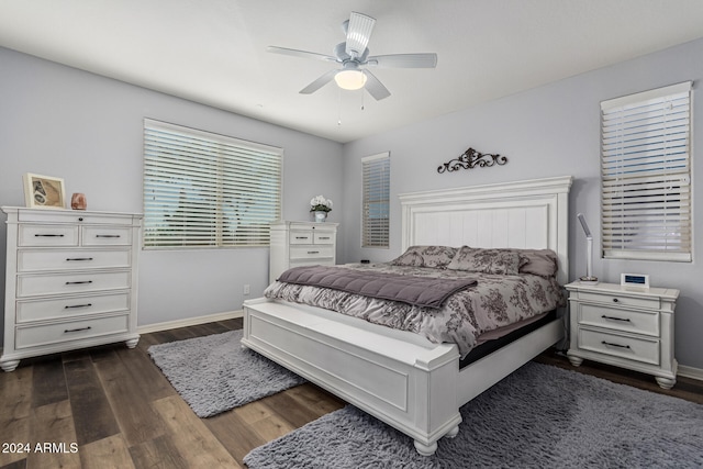 bedroom with a ceiling fan, baseboards, and dark wood-type flooring