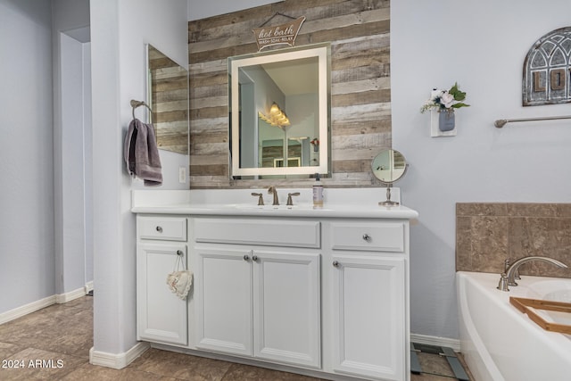 bathroom with wooden walls, vanity, baseboards, and a bath