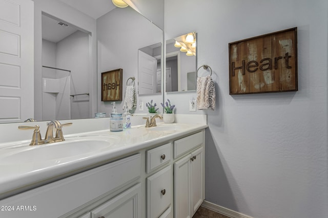 full bath featuring double vanity, visible vents, a shower, and a sink