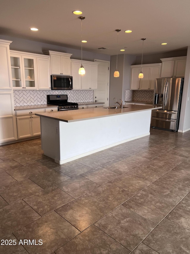 10637 W Eucalyptus Rd, Peoria, AZ 85383 - kitchen with stainless steel appliances, tasteful backsplash, a center island with sink, a sink, and hanging light fixtures