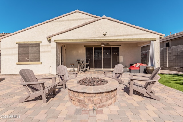 exterior space featuring a ceiling fan, an outdoor fire pit, a patio area, and stucco siding