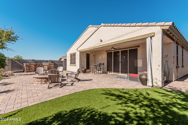 rear view of property with ceiling fan, a fenced backyard, a yard, stucco siding, and a patio area