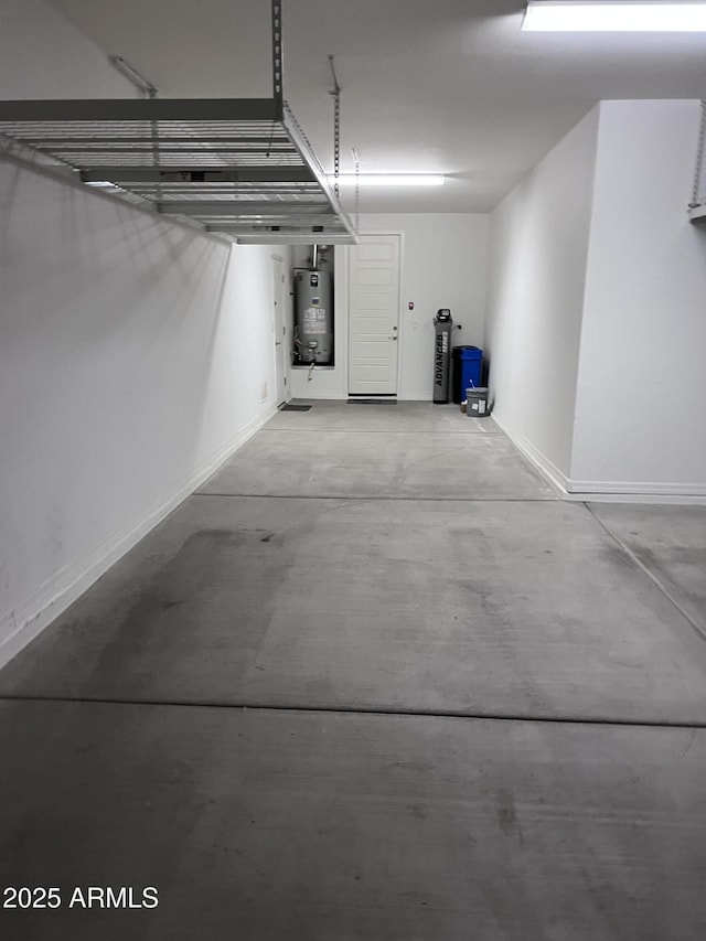 garage featuring water heater and baseboards