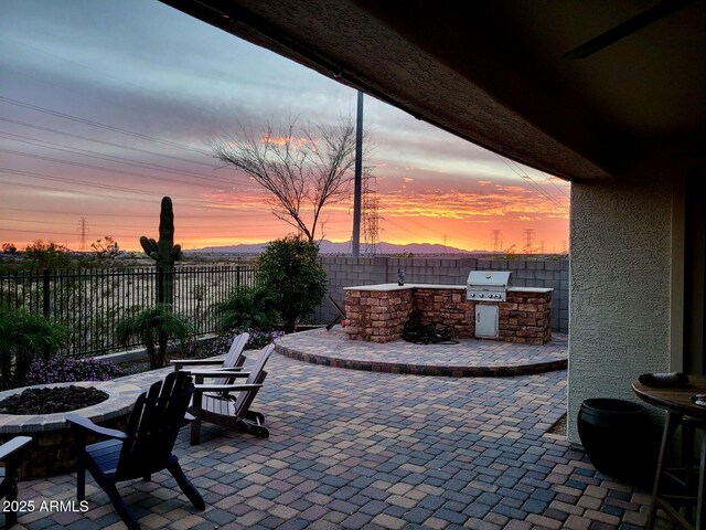 10637 W Eucalyptus Rd, Peoria, AZ 85383 - patio terrace at dusk with an outdoor fire pit, a patio area, and a fenced backyard