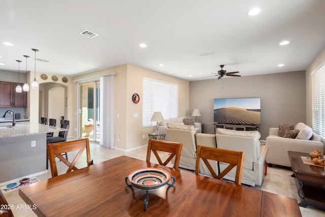 living room featuring ceiling fan, visible vents, arched walkways, baseboards, and recessed lighting