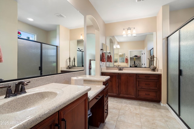 bathroom featuring visible vents, two vanities, a sink, and a stall shower