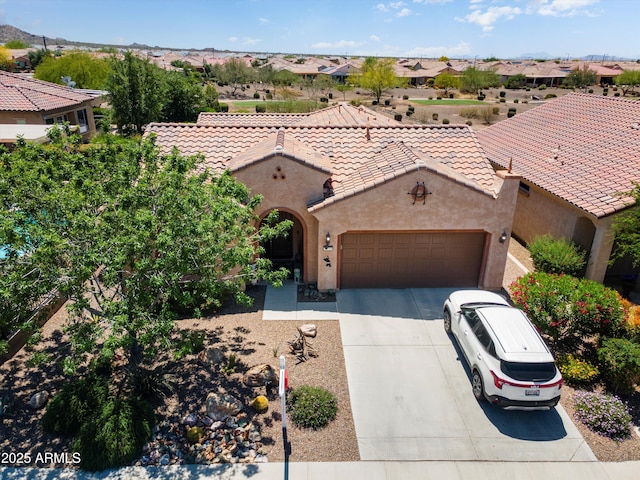view of front of property with an attached garage, stucco siding, a tiled roof, and concrete driveway