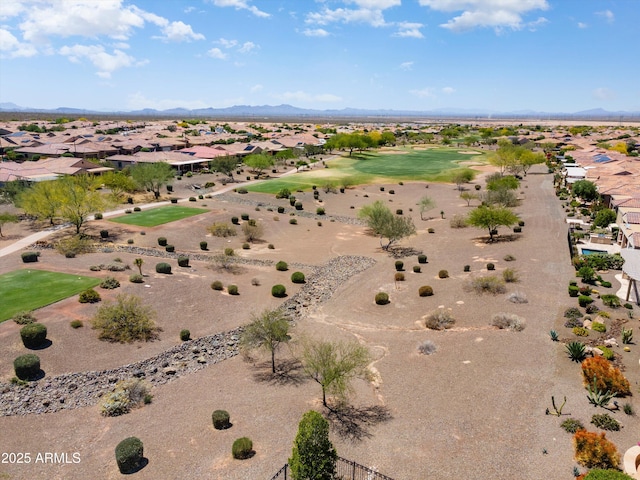 drone / aerial view featuring a residential view, a mountain view, a desert view, and golf course view