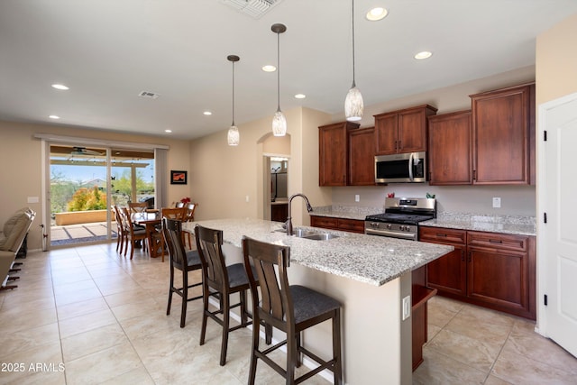 kitchen with a sink, arched walkways, stainless steel appliances, recessed lighting, and visible vents