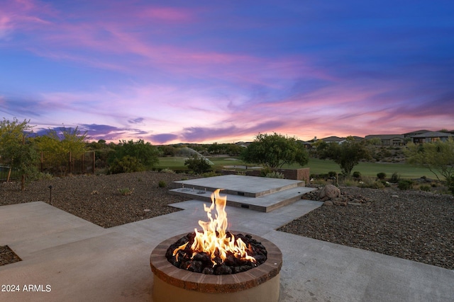 patio terrace at dusk featuring a fire pit