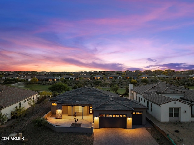 view of front of house featuring a garage and a patio area