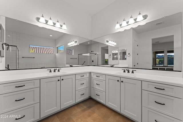 bathroom with walk in shower, vanity, and tile patterned flooring