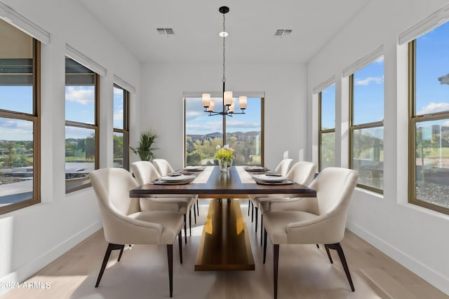 dining space with a notable chandelier and light hardwood / wood-style flooring